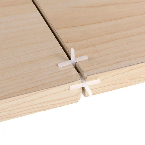 Close-up of One Sixteenth Inch Tile Spacers Set, 500 Pcs Cross Tile Leveling Clips for ceramic tile installation on floors and walls.