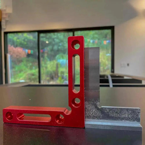 Pro Grade 4 Inch Machinist Square Engineer Right Angle Ruler with Seat in stainless and red design, on a table.