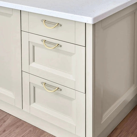 Brushed Brass And Brushed Nickel Cabinet Pulls 5 Inch Center To Center Curved Handles installed on white kitchen drawers.