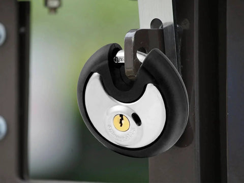 Outdoor Stainless Steel Disc Padlock With Waterproof Shield And Rubber Bumper installed on gate for security