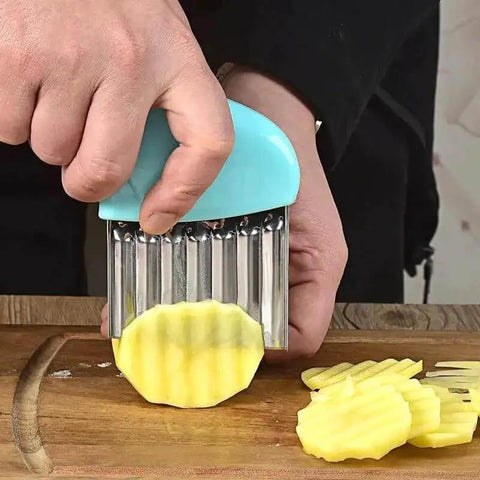 Person using 4 Piece Crinkle Cutter Set For Veggies Stainless Steel Wavy Cutter Ideal For Potatoes Carrots Chips Lettuce And Butter Assorted Colors Black Blue Pink Kid Friendly Durable ABS Handle Safe Kitchen Tool to slice potatoes on a wooden board, featuring blue ABS handle and wavy 430 stainless steel blade.