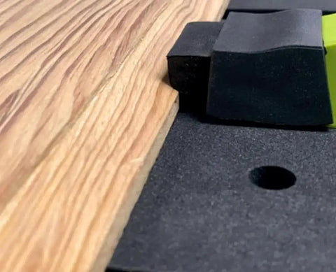 Close-up of Low Profile Clamp Kit for CNC Machines MFT Tables with clamp and fence on wood surface for secure workholding.