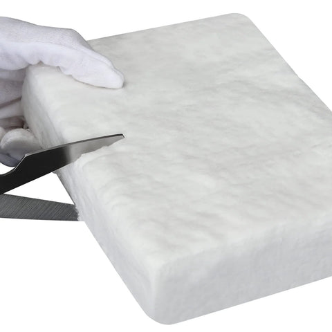 Ceramic fiber blanket, 12x24x2 in, white insulation being cut with scissors by gloved hand