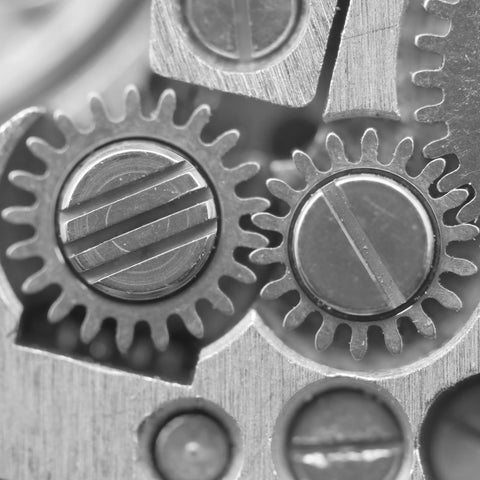 Close-up of silver gears illustrating a mechanical concept, highlighting details of interlocking teeth and precision engineering.