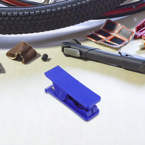 TEHAUX bike hydraulic brake hose cutter tool, blue plastic, on a workbench with a tire and repair accessories