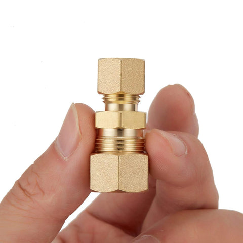 Brass compression tube fitting union, 3/8 in x 1/4 in tube OD, held between fingers