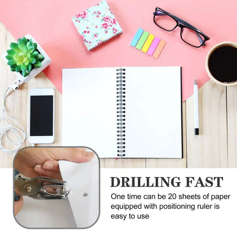 Metal Single Hole Puncher With Ergonomic Handles And Built In Guide punching paper in office setting with coffee and notebook