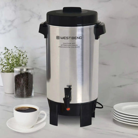 42-Cup Coffee Urn With Automatic Temperature Control on kitchen counter, silver with black handles and faucet.