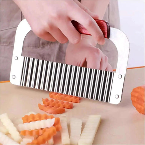 Handheld Crinkle Cutter for Veggies and Potatoes Stainless Steel Wavy Potato Chopper Knife slicing vegetables on a cutting board.