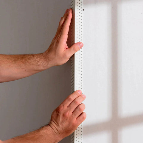 Hands applying drywall corner bead using drywall corner bead spray adhesive 13.8 oz can, contractor-grade fast-grab aerosol.