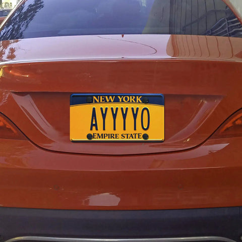 Rear view of a car with a New York license plate displaying 'AYYYY0' secured with Stainless Steel License Plate Screws Kit For Car With Anti Theft Hardware M6 25mm 1 Quarter Inch Black Caps Bolts Nuts Fasteners Includes Anti Theft Screwdrivers Rust Proof.