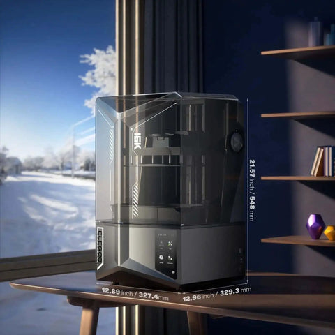 Saturn 4 Ultra 16K Resin 3D Printer With 10 Inch Mono LCD on desk, showing transparent lid, in modern room with window view