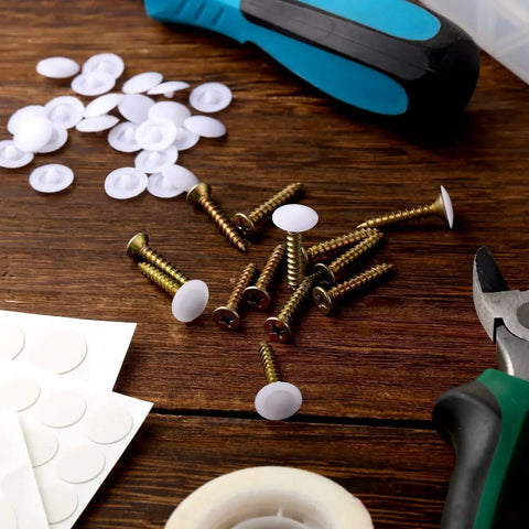 Plastic Self Tapping and Self Adhesive Screw Hole Covers for Wood Furniture, screws, covers, and tools on a wooden surface