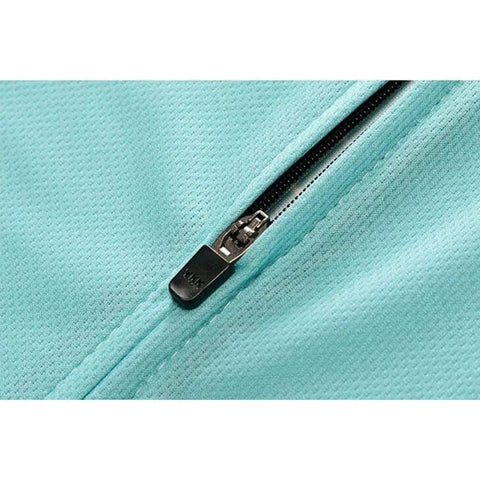 Close-up of a turquoise fabric zipper on a garment, with textured material and silver zipper teeth visible.