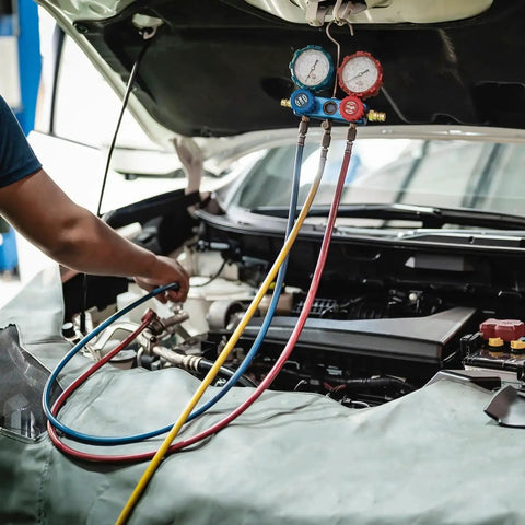 Pneumatic air tubing set with blue, yellow, and red hoses connected to a dual-gauge manifold under a car hood