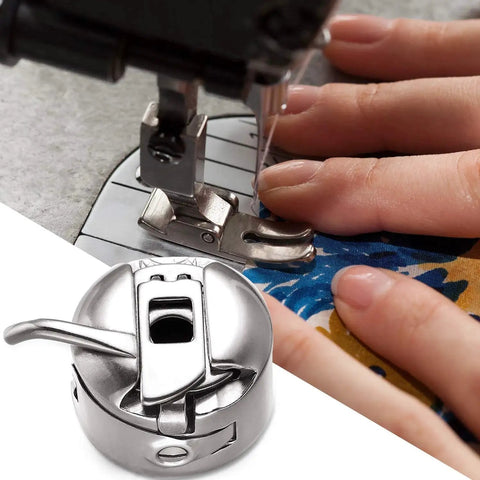 Stainless steel bobbin case for front-loading 15-class sewing machines; two-view: presser foot top, bobbin housing bottom.