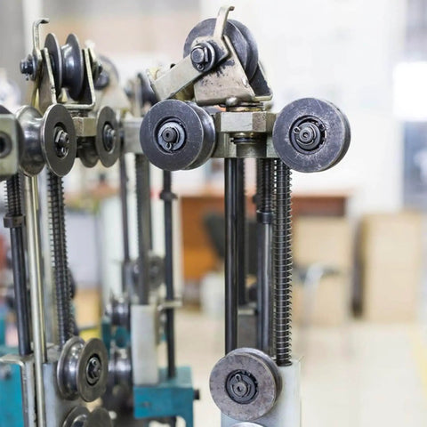 Industrial machine with metal gears and pulleys in a manufacturing setting
