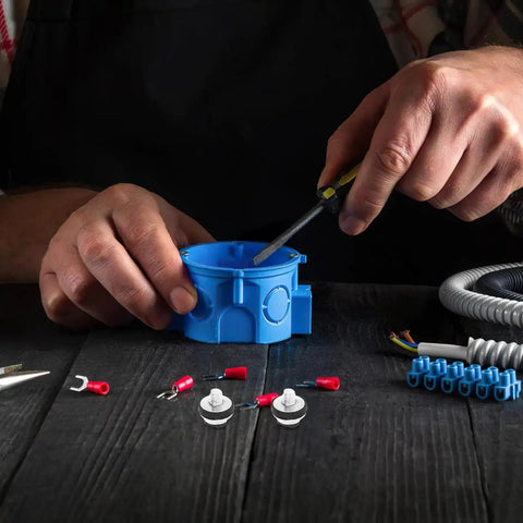 Person using screwdriver on blue plastic component with hardware parts on table