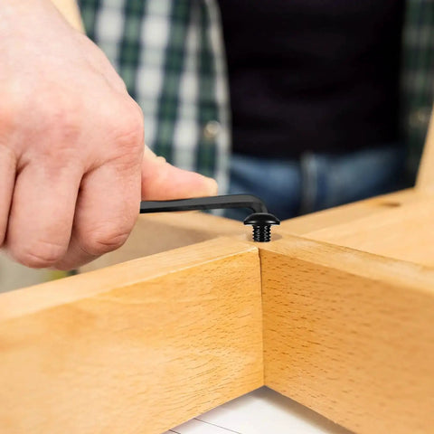 Person using spanner on M6 hex socket screw in wood, part of Heavy Duty 178 Piece M6 Screws And Nuts Set With Hex Socket Button Head Cap Screws Metric.