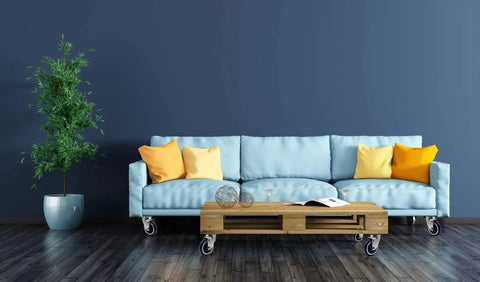 Blue sofa with orange and yellow pillows on 4 inch polyurethane shopping cart wheels pack of four with potted plant, hardwood floor