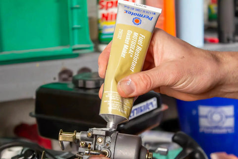 Applying MotoSeal 1 Ultimate Gasket Maker Grey to engine joint, 2.7 oz tube, gasoline resistant, flexible seal on irregular surfaces.