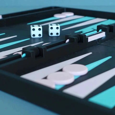 Close-up of a backgammon board with dice and pieces, featuring a black and white design with teal accents.