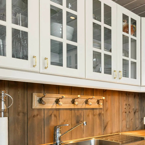 Brushed Brass 3 Inch Cabinet Handles Set Of 10 In Solid Zinc Alloy installed on white kitchen cabinets over a wooden backsplash.