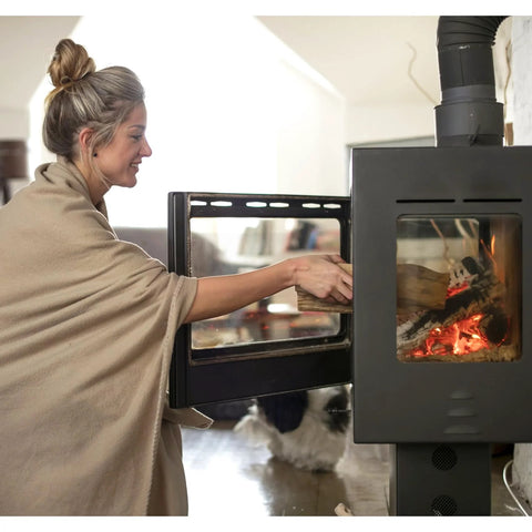 Stove gasket tape, 5/8 in width and 1/8 in thick, fiberglass, self-adhesive; woman loads wood into a black stove.
