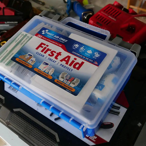 OSHA Compliant First Aid Kit For 50 People With 260 Pieces All Purpose Emergency Supplies shown in a clear box on a tool bench
