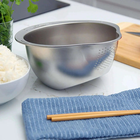Stainless Steel Rice Washer Strainer Bowl With Agitator Bumps for quick no fuss rinsing, on a kitchen countertop near rice and chopsticks.