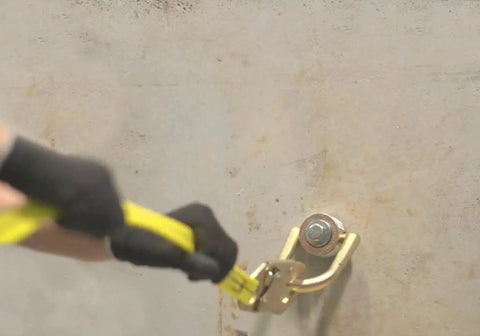 Close-up of hand using 10K Swivel Anchor Five Eighths Inch By Six Inches Expansion Anchor With Full Size D Ring In Zinc Plated Stainless Steel installed on wall.