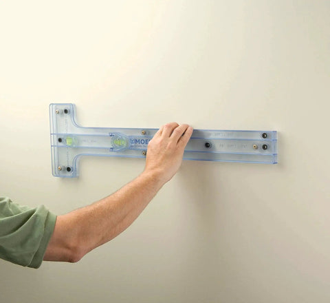 Hand holding installation guide on wall for Mason Chrome Tissue Paper Holder Roller Only With Pro Fit Installation System Easy Wall Mount 5.62 Inch Long