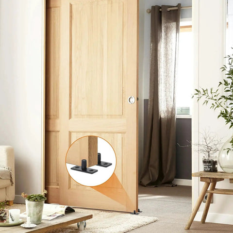 Bottom Mount Barn Door Floor Guide Two Pack T Shape Matte Black Roller Guides for Grooved or Ungrooved Doors installed in room.