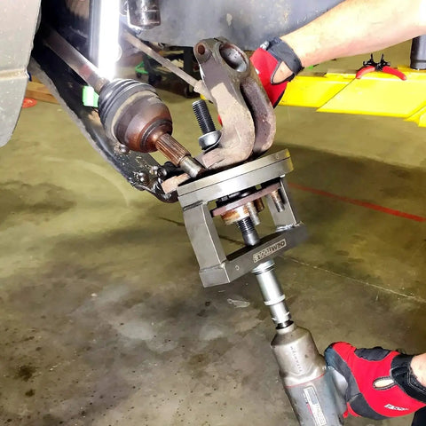 Mechanic using Master Wheel Bearing Removal Tool And Installer Kit with self-centering design on vehicle hub.