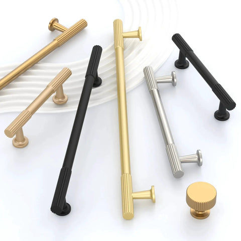 Assorted cabinet handles in champagne bronze, black, and silver finishes displayed on a white surface