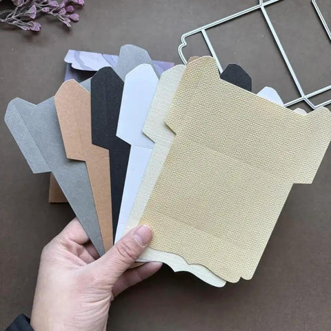 Hand holding various paper cuts from Must Have Envelope Die Set For Scrapbooking And Card Making with Layer Frame Net Metal Cutting Dies.