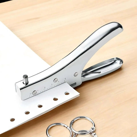 Handheld Single Hole Puncher With 1.9 Inch Throat Punches Up To 10 Sheets on wooden table next to metal rings, heavy duty metal paper punch for crafting and office use