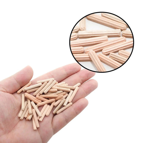 Hand holding 48 pack 4mm by 25mm dowel pins with fluted beveled ends for tight wood joints and shelf support hardwood dowels.