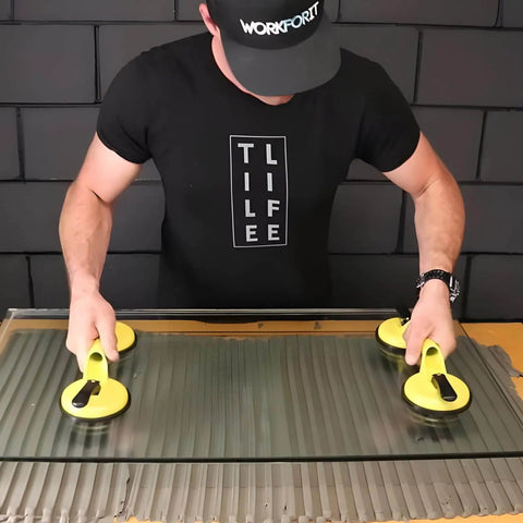 Person using Heavy Duty Aluminum Suction Cups With Vacuum Handle Glass And Tile Lifter for lifting large glass, ergonomic grip focus.