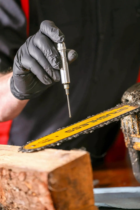 Precision Oiler Pen Applicator For Tight Spaces used to apply lubricant to a chainsaw blade, showing aluminum pen and needle tip.