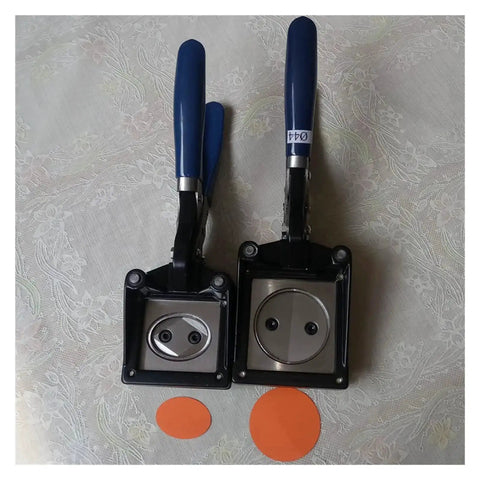 Two handheld button graphic punch die cutters with 32mm hardened steel dies, durable composite frames, and blue handles for badge making.