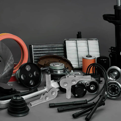 Assorted automotive engine components including filters, gears, and metal parts displayed on a surface.