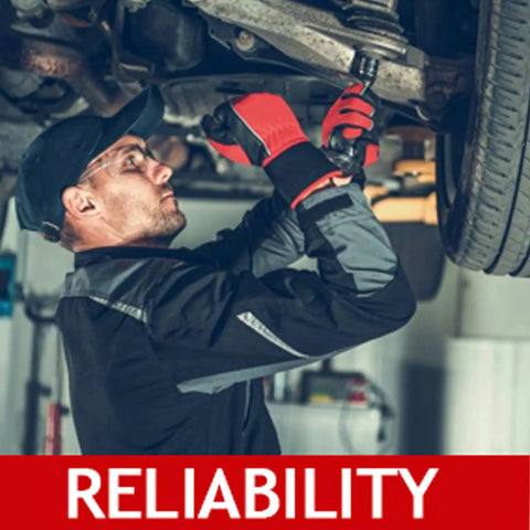 Side view of automotive technician under a lifted vehicle installing sway bar stabilizer link kit, red gloves visible