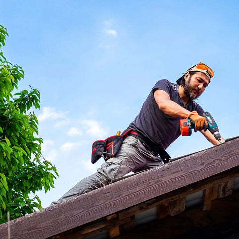 A DIY enthusiast using a drill on a rooftop, wearing safety gear. Partial view of 22 Piece Titanium Screw Extractor Set For Stripped Screws And Bolts.