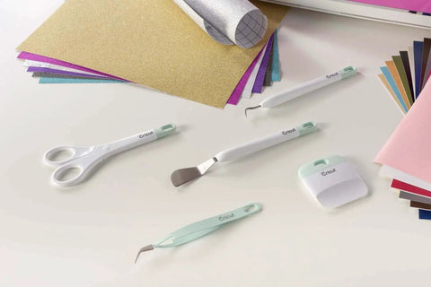Go-To 5-Piece Craft Tool Set for Precision Lifts Snips Burnish and Weed by Cricut on table with colorful paper sheets