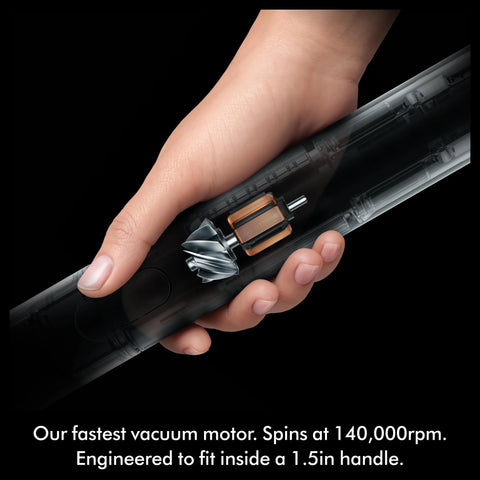 Dyson PencilVac Fluffycones cordless vacuum, transparent tube with turbine blades and copper motor, held in hand.