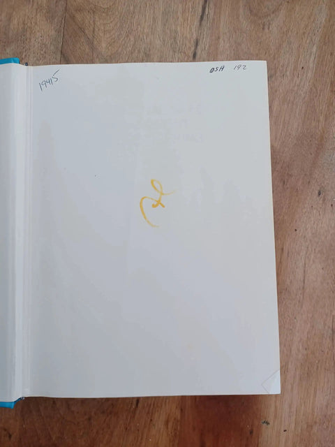 Book: Occupational Safety Management and Engineering, front interior page with a small orange doodle on white page on a wooden table.