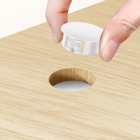 Inserting a white nylon hole plug from the 200 Piece White Nylon Hole Plug Set With Nine Sizes From One Fifth Inch To One Inch into wooden surface hole.