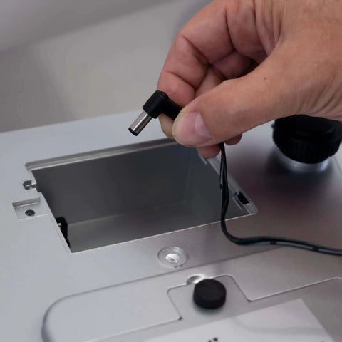 Person connecting power cable to Heavy Duty Spill Proof Digital Kitchen And Industrial Scale With 66 Lb Capacity Dual Front And Rear Display