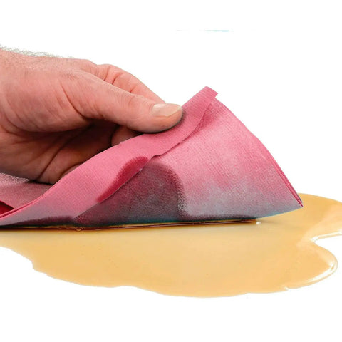 Hand using Heavy Duty Red Quick Rags Jumbo Roll For Industrial Cleaning 475 Sheets Per Roll One Roll Per Case on spill